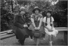 [Walentyna Bereźnicka i córka Bronisława Bereźnicka siedzące na ławce w parku w towarzystwie kobiety]